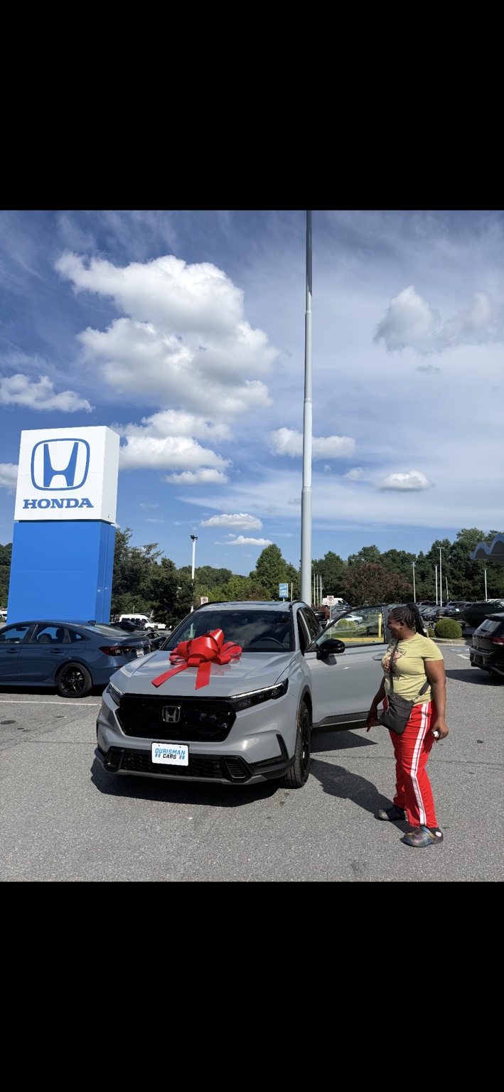 Customer beside a white Honda SUV with a red bow