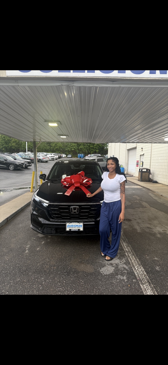 Customer beside a black Honda SUV with a red bow