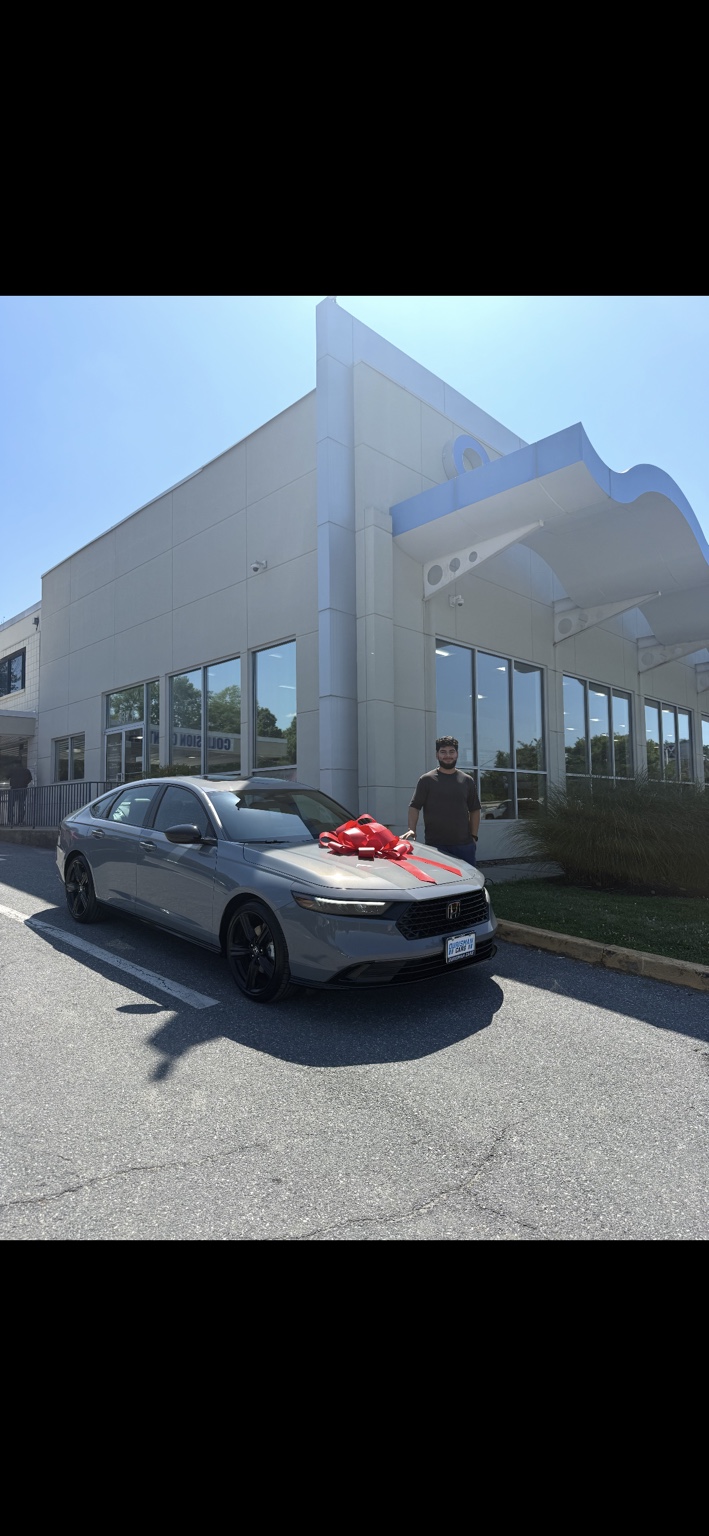 Customer beside a gray Honda sedan with a red bow