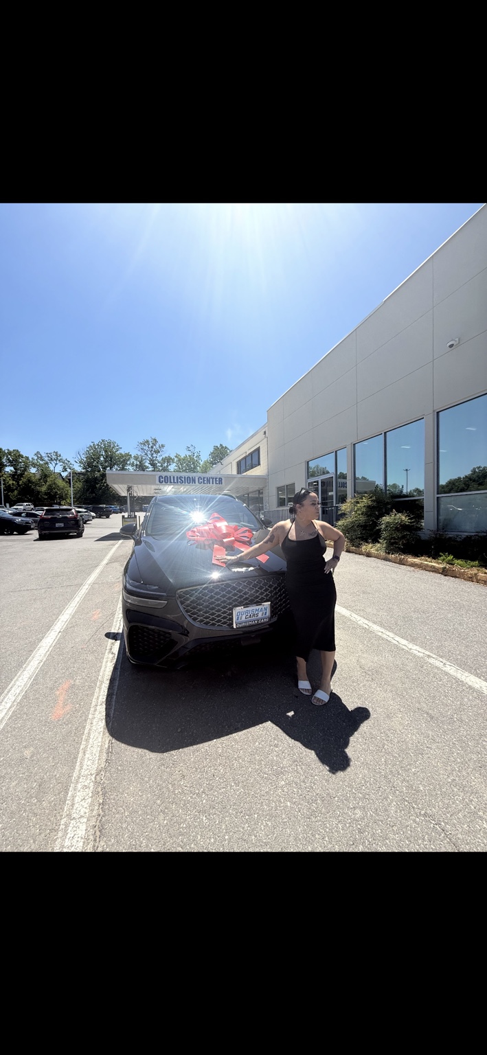 Customer beside a dark SUV with a red bow