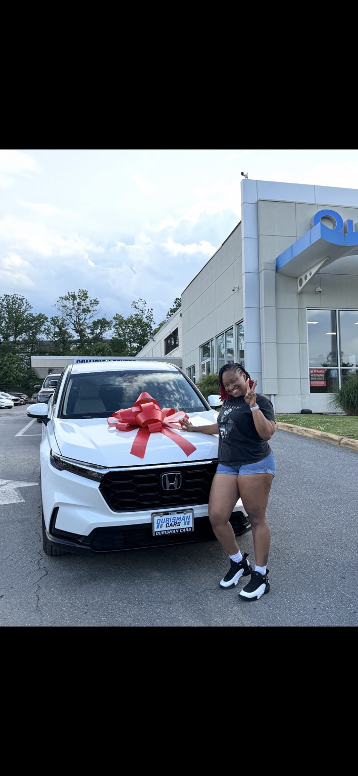 Customer beside a white Honda SUV with a red bow
