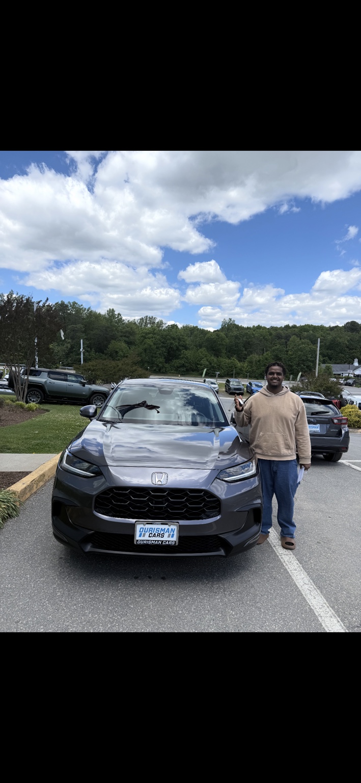 Customer with keys beside a gray Honda SUV