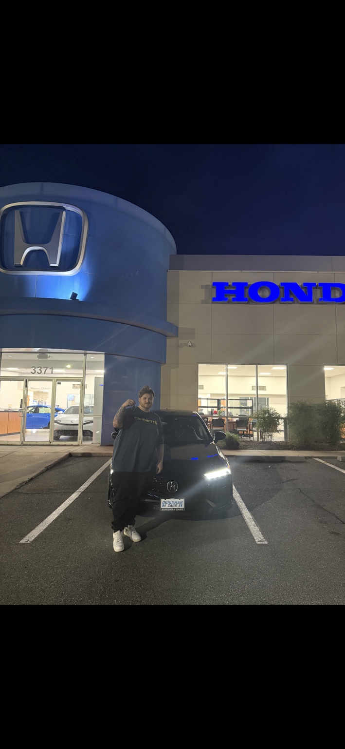 Customer beside a black Acura at night