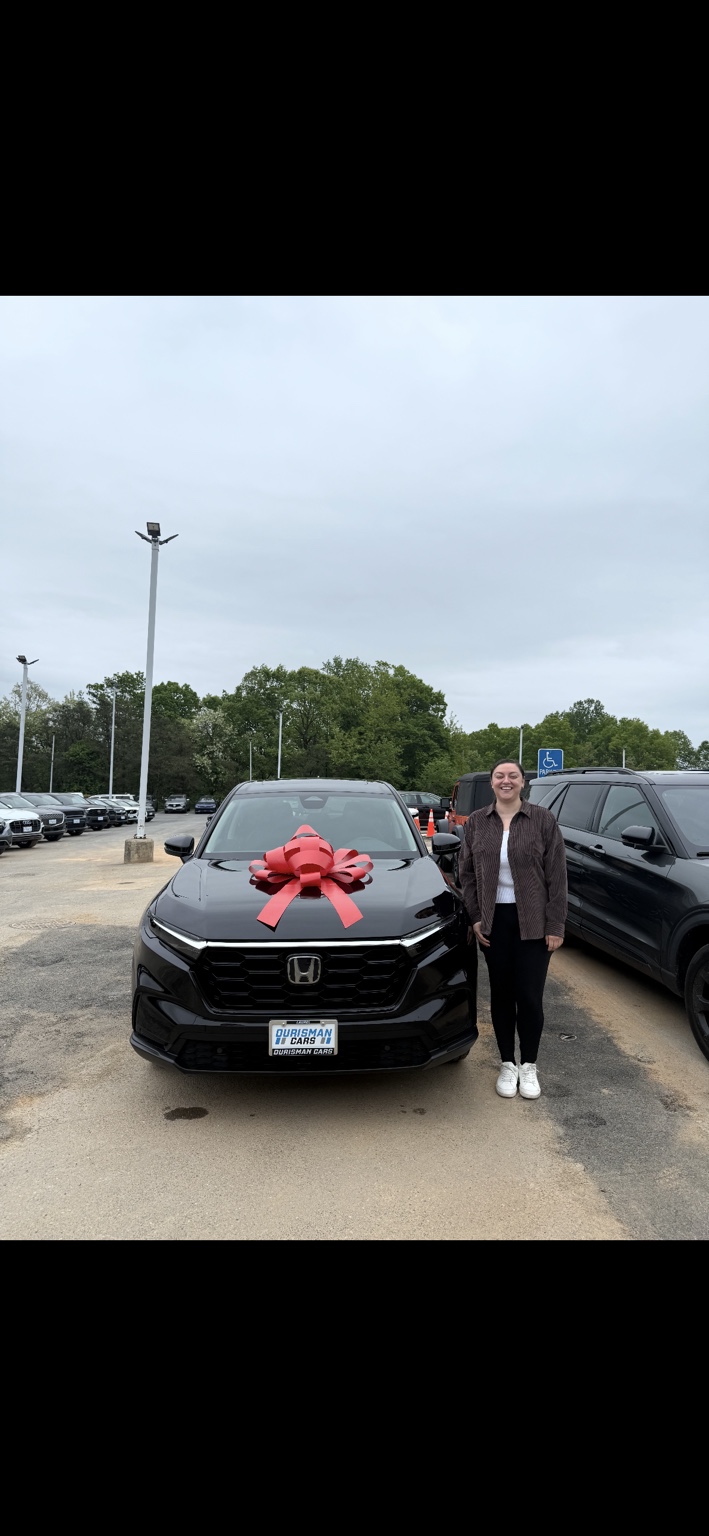 Customer beside a black Honda SUV with a red bow