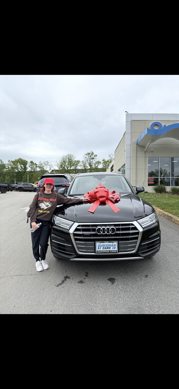 Customer beside a black Audi SUV with a red bow