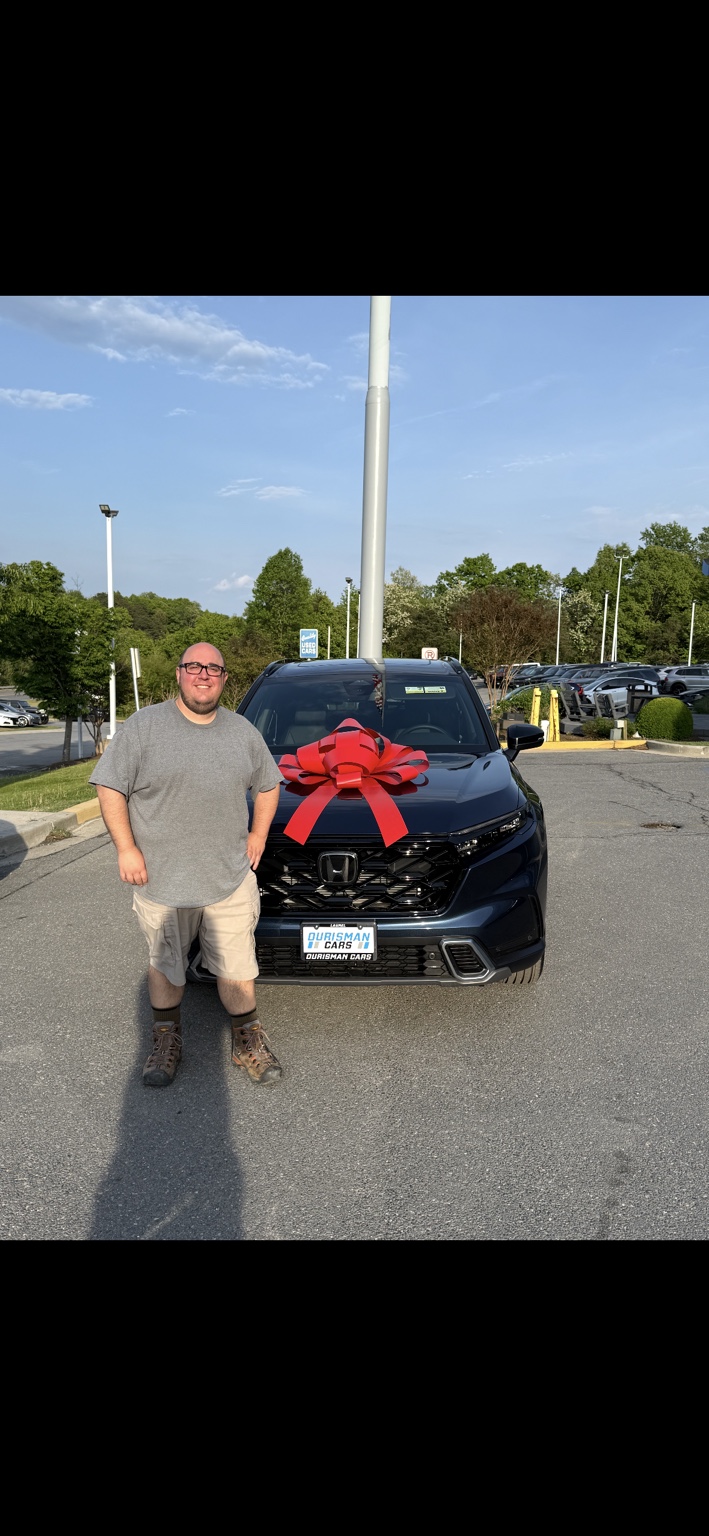 Customer beside a dark Honda SUV with a red bow