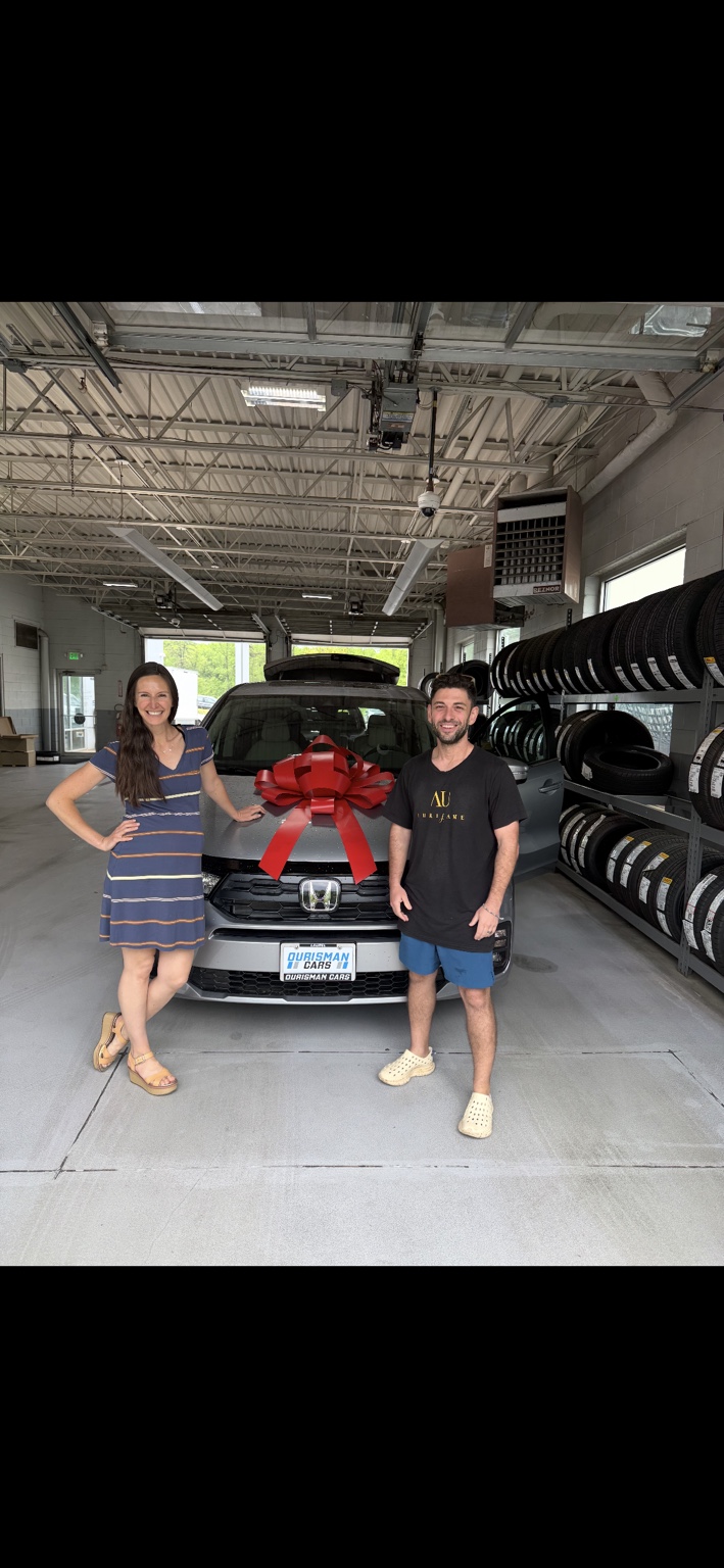 Two customers beside a gray Honda with a red bow