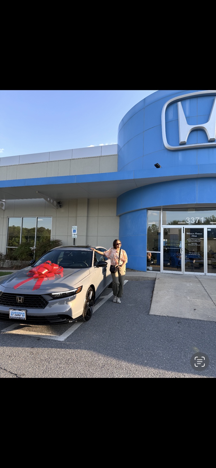 Customer beside a silver Honda sedan with a red bow