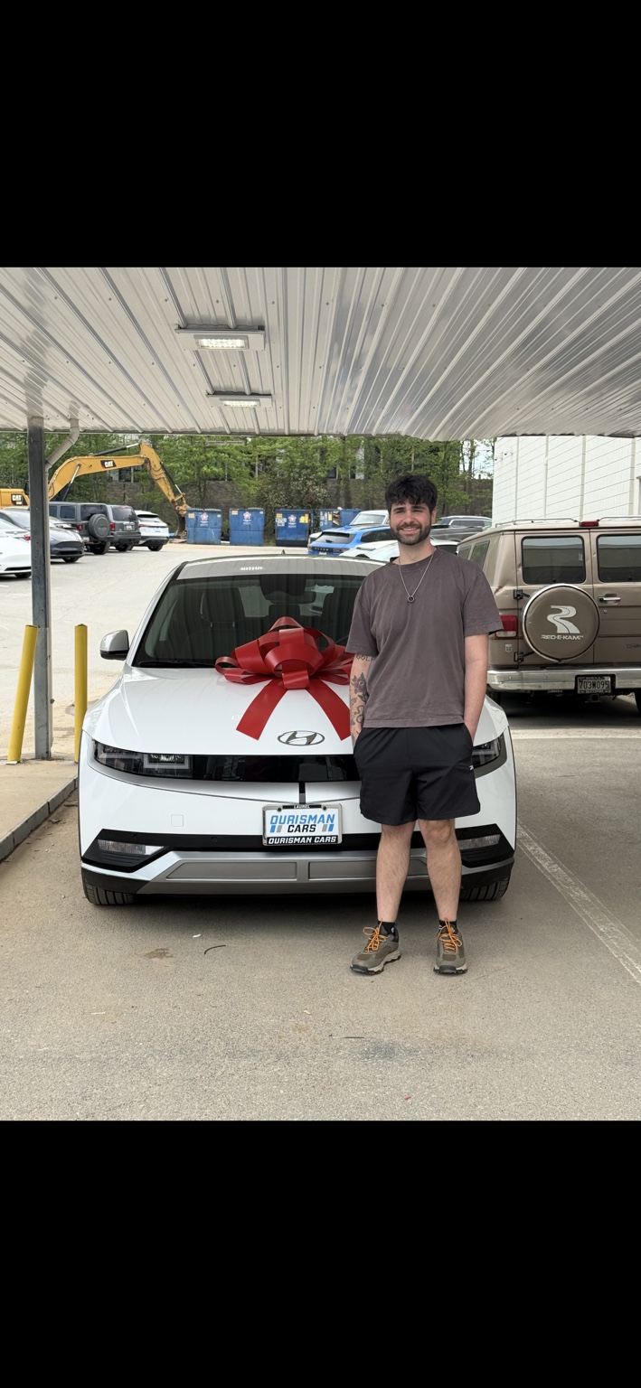 Customer beside a white Hyundai with a red bow