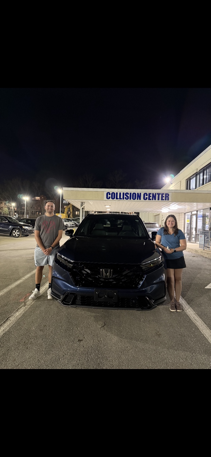 Two customers beside a dark Honda SUV at night