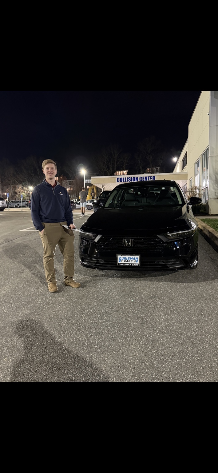 Customer beside a black Honda minivan at night