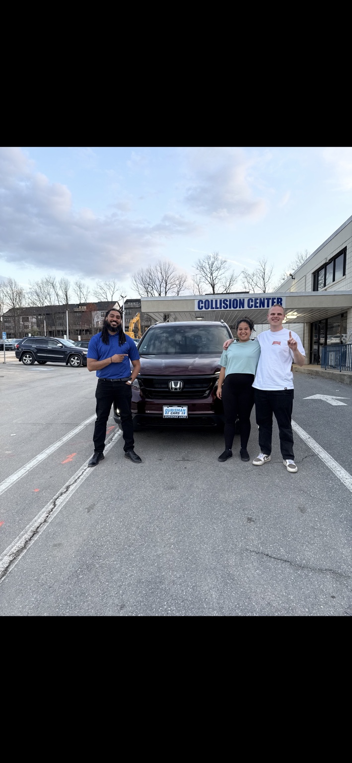 Three people beside a maroon Honda SUV