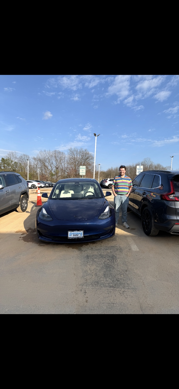Customer beside a blue Tesla
