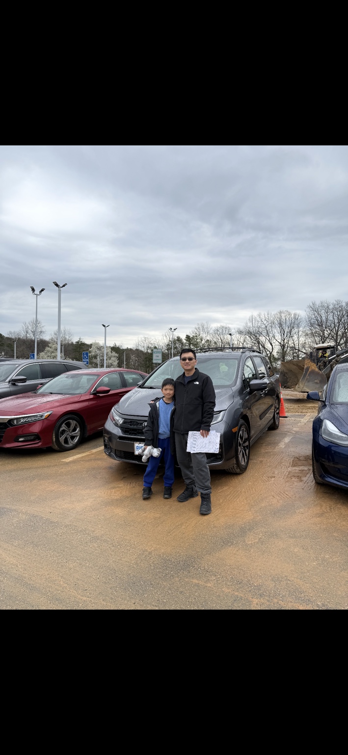 Customer and child beside a gray SUV