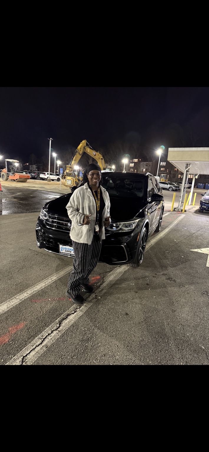 Customer beside a dark SUV at night