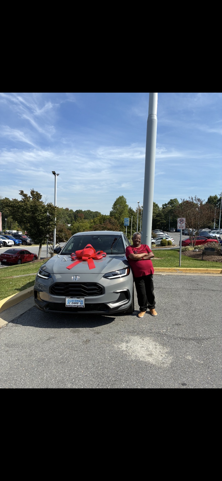 Customer beside a silver Honda SUV with a red bow